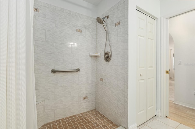 bathroom with walk in shower and tile patterned flooring