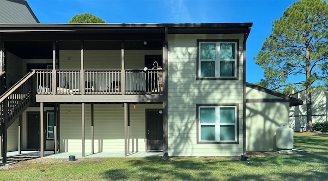 rear view of property featuring a lawn