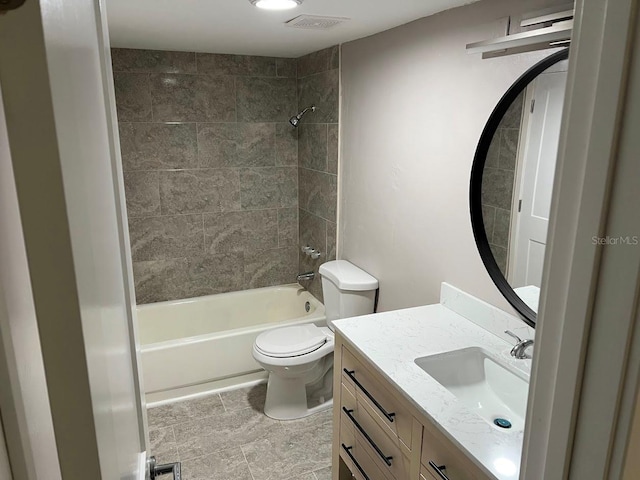 full bathroom featuring toilet, vanity, and tiled shower / bath