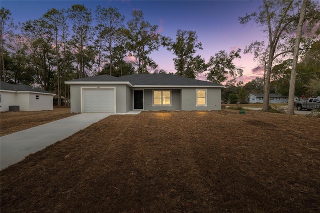 ranch-style home with a garage and cooling unit