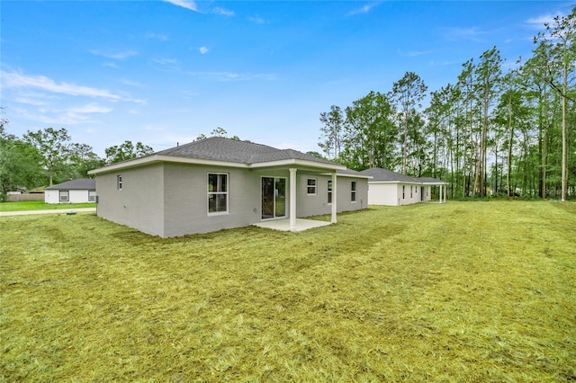 rear view of house featuring a patio and a lawn