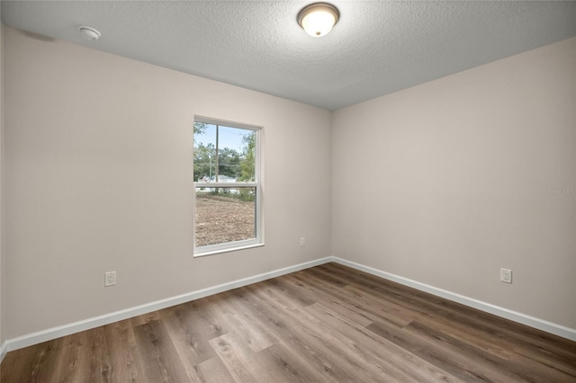 spare room with hardwood / wood-style flooring and a textured ceiling