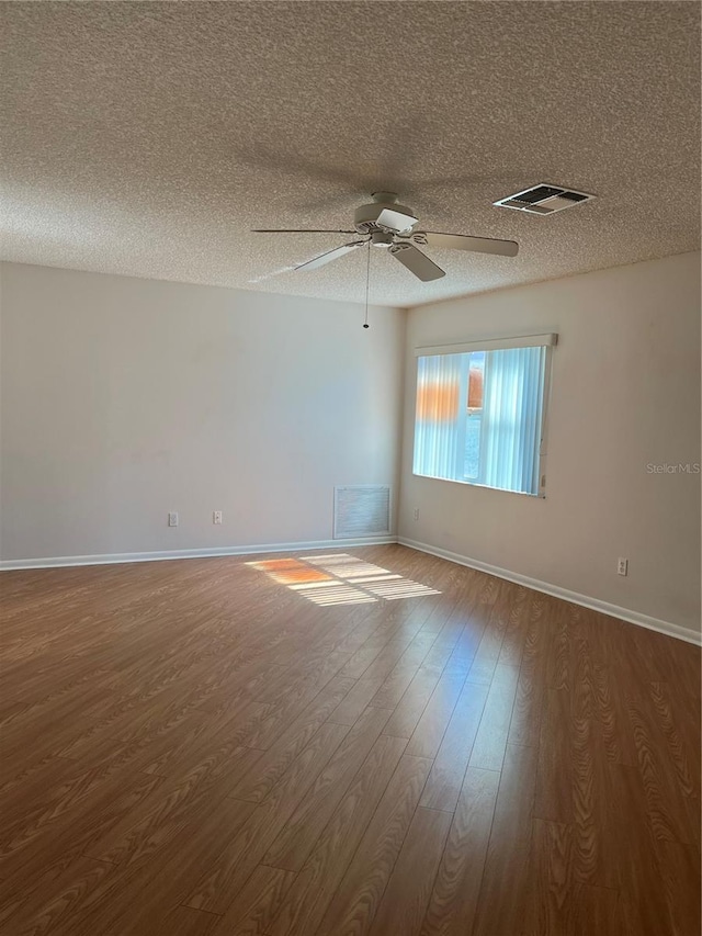 spare room featuring a textured ceiling, ceiling fan, and wood-type flooring