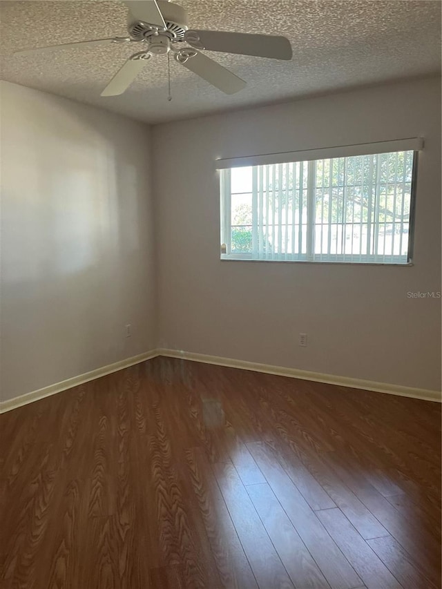 unfurnished room with ceiling fan, dark hardwood / wood-style flooring, and a textured ceiling