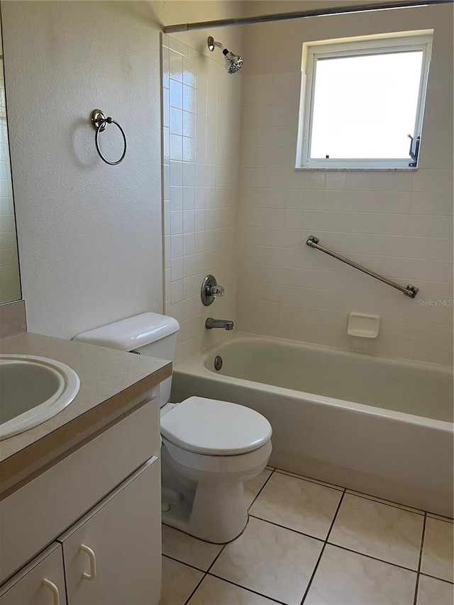 full bathroom with toilet, tiled shower / bath, tile patterned floors, and vanity