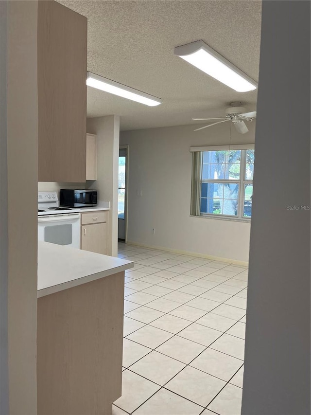 kitchen with a textured ceiling, ceiling fan, white electric range, and light tile patterned floors