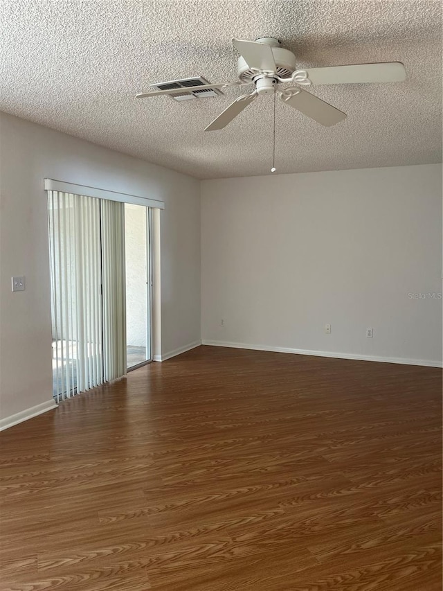 empty room featuring a textured ceiling, ceiling fan, and dark hardwood / wood-style floors