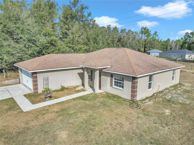 single story home with a garage and a front lawn