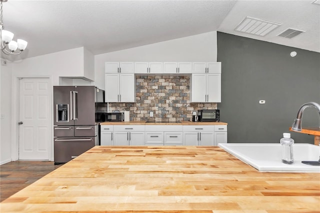 kitchen with pendant lighting, wooden counters, white cabinets, tasteful backsplash, and black appliances