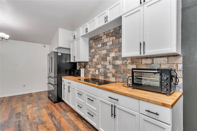 kitchen featuring black electric cooktop, white cabinetry, and wooden counters