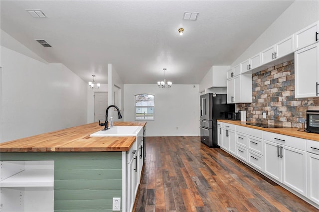 kitchen featuring decorative light fixtures, white cabinetry, wooden counters, and tasteful backsplash