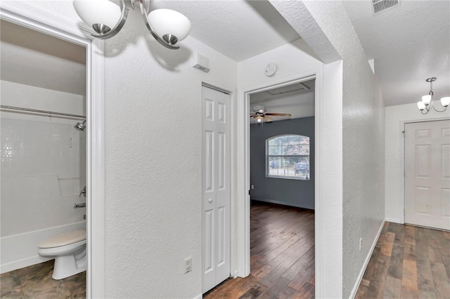 bathroom featuring wood-type flooring, shower / bathing tub combination, a textured ceiling, and an inviting chandelier