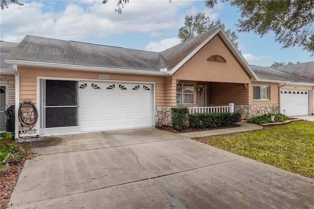 ranch-style home featuring a garage, a front yard, and covered porch