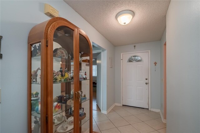 entryway featuring a textured ceiling and light tile patterned flooring