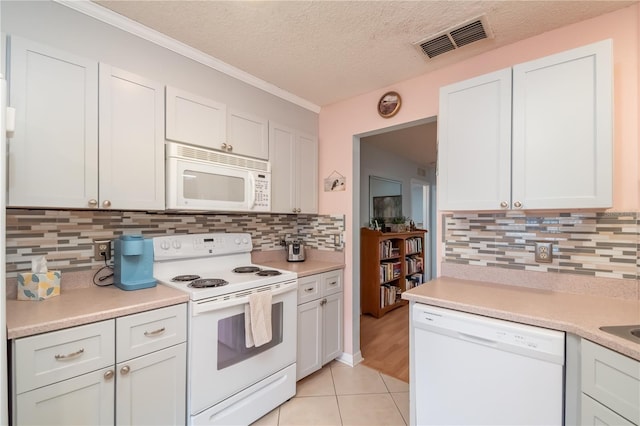 kitchen featuring backsplash, white appliances, white cabinets, and a textured ceiling