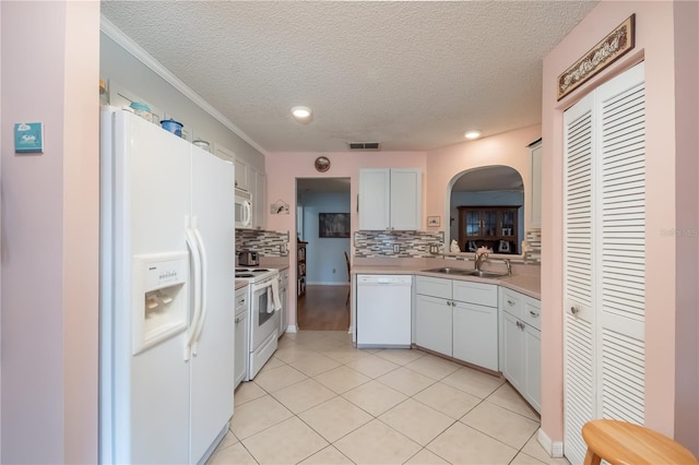 kitchen featuring sink, white cabinetry, white appliances, and decorative backsplash