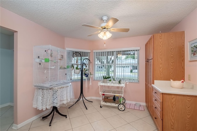 miscellaneous room featuring a textured ceiling, light tile patterned floors, and ceiling fan