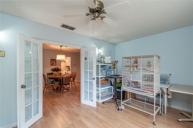 office space with ceiling fan, hardwood / wood-style floors, a textured ceiling, and french doors