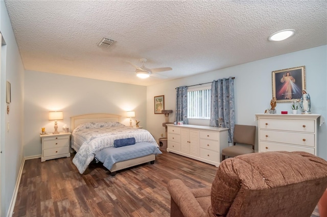 bedroom with ceiling fan, dark wood-type flooring, and a textured ceiling