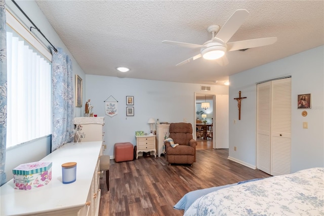 bedroom featuring a closet, ceiling fan, a textured ceiling, and dark hardwood / wood-style flooring