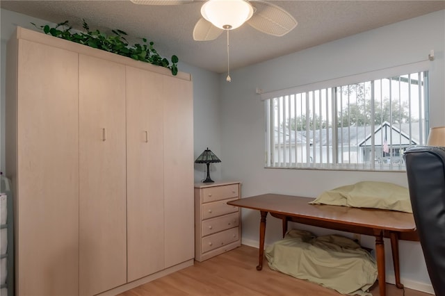 interior space with light hardwood / wood-style floors, a textured ceiling, and ceiling fan