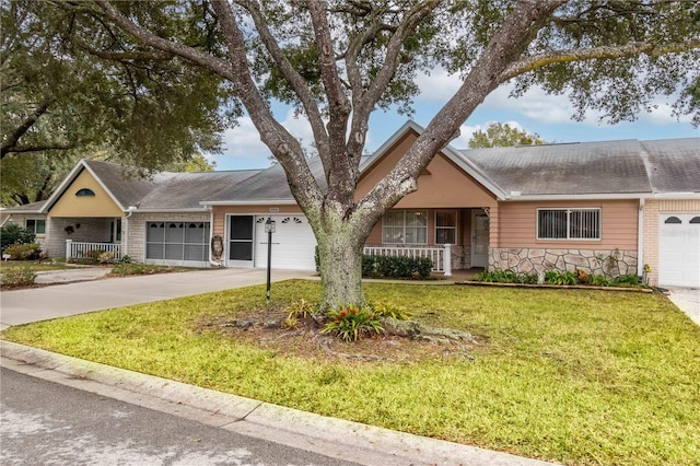 single story home featuring covered porch, a garage, stone siding, driveway, and a front lawn