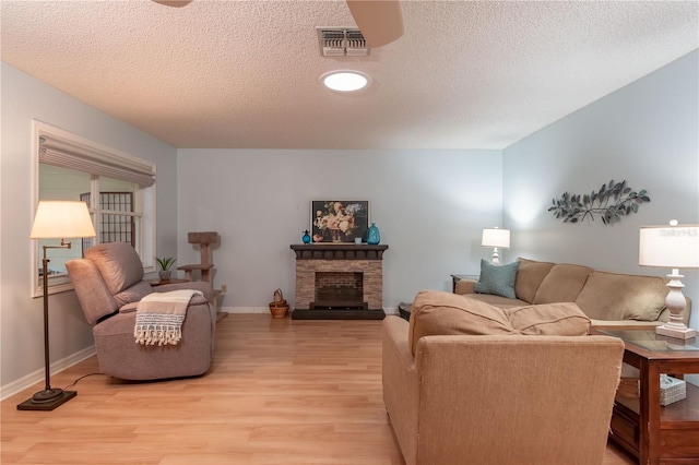 9051 SW 96th Ln Unit B, Ocala, FL 34481 - living area featuring light wood-style floors, a textured ceiling, baseboards, and a fireplace