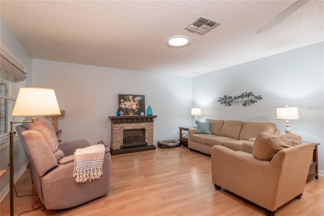 9051 SW 96th Ln Unit B, Ocala, FL 34481 - living area with light wood-style floors, a textured ceiling, and a fireplace