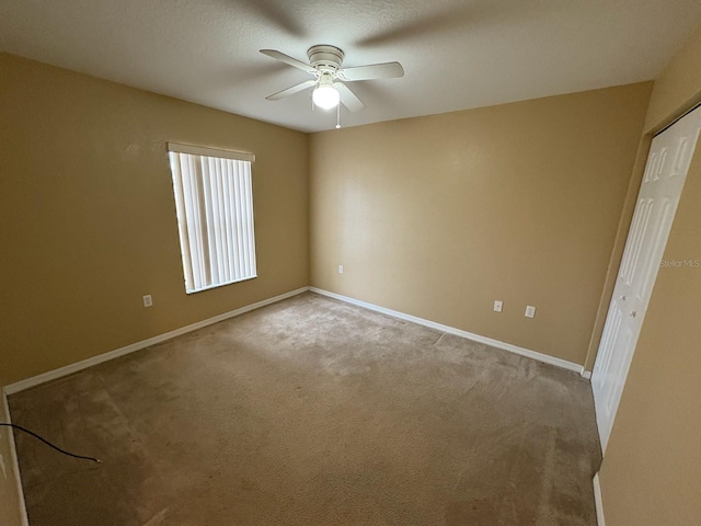 empty room featuring light carpet and ceiling fan