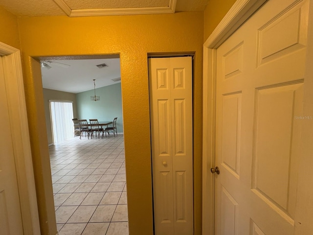 hallway featuring vaulted ceiling and light tile patterned floors