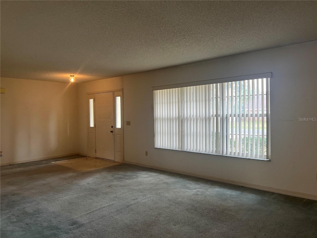 carpeted foyer entrance featuring a textured ceiling