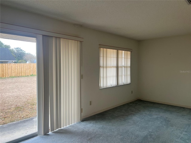 carpeted spare room featuring a textured ceiling