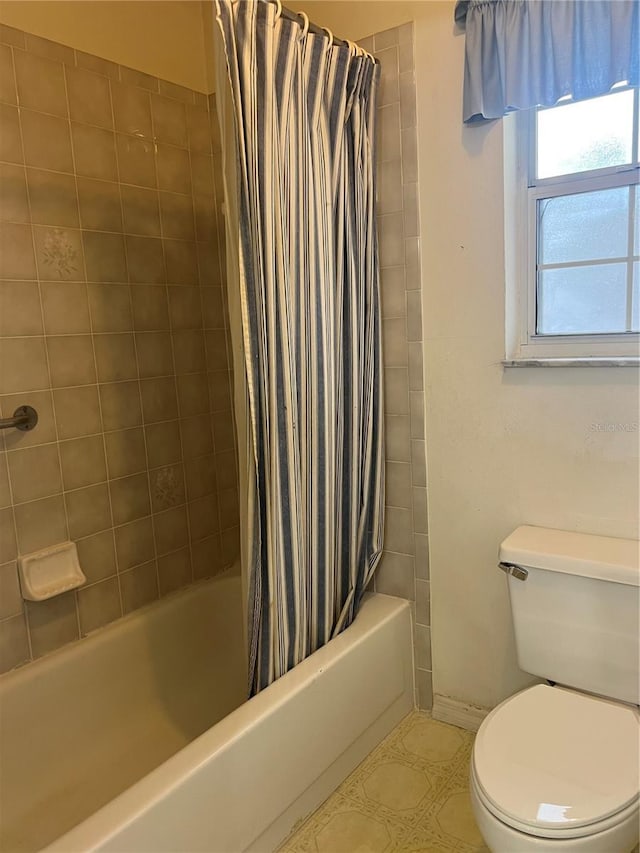 bathroom featuring toilet, tile patterned floors, and shower / bath combo with shower curtain