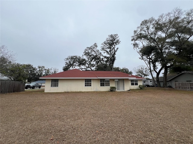 back of house with fence and stucco siding