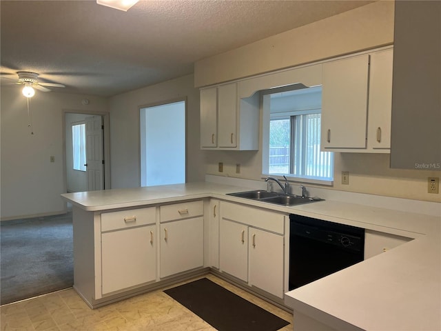 kitchen with black dishwasher, a peninsula, a sink, and light countertops