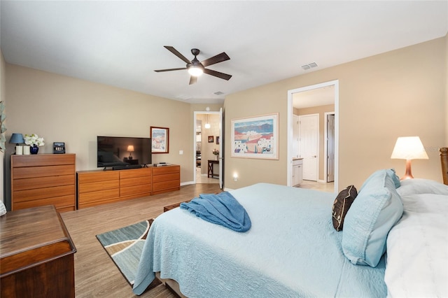 bedroom featuring ceiling fan, light wood-type flooring, and connected bathroom