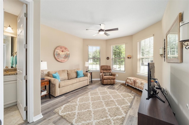 living room featuring ceiling fan and light hardwood / wood-style floors