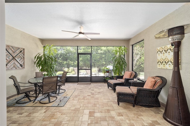 sunroom / solarium featuring ceiling fan and a healthy amount of sunlight