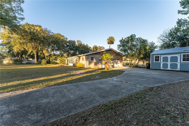 ranch-style home featuring a storage shed and a front lawn