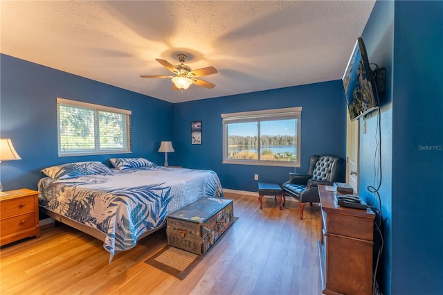 bedroom featuring multiple windows, ceiling fan, and hardwood / wood-style floors