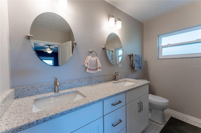 bathroom with a textured ceiling, ceiling fan, toilet, tile patterned floors, and vanity