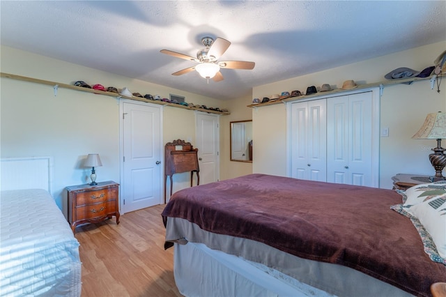 bedroom featuring ceiling fan, light hardwood / wood-style flooring, a closet, and a textured ceiling