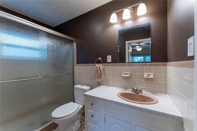 bathroom featuring toilet, a textured ceiling, walk in shower, tile walls, and ceiling fan