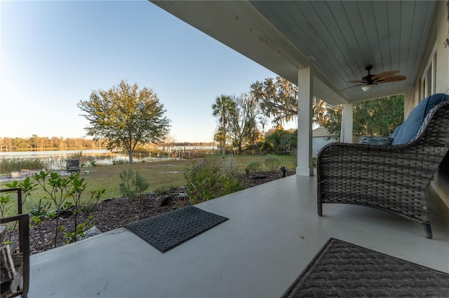 view of patio featuring ceiling fan and a water view