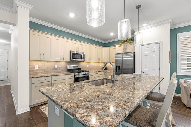 kitchen with a center island with sink, stainless steel appliances, decorative backsplash, hanging light fixtures, and sink