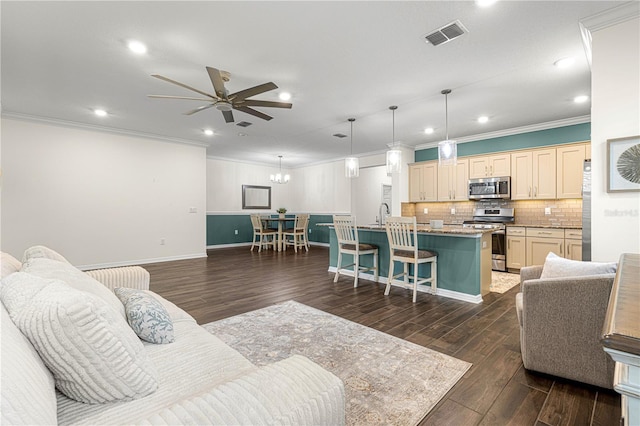 living room featuring ceiling fan, sink, dark hardwood / wood-style flooring, and ornamental molding