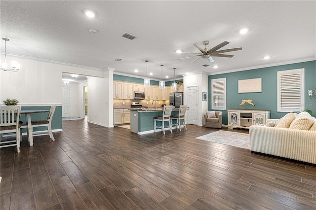 living room featuring ceiling fan with notable chandelier, a textured ceiling, sink, dark hardwood / wood-style floors, and crown molding