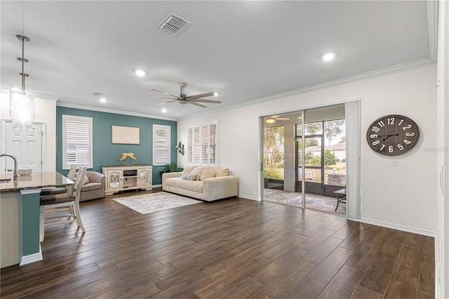 living room featuring ceiling fan, a textured ceiling, and ornamental molding