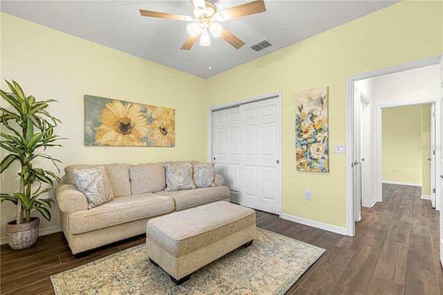 living room with ceiling fan and dark wood-type flooring