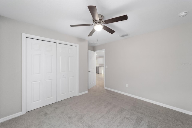 unfurnished bedroom featuring visible vents, baseboards, carpet flooring, a closet, and a ceiling fan